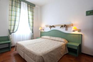 Un dormitorio con una cama verde y una ventana en Hotel Clelia, en Deiva Marina