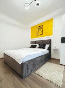 una camera da letto con un letto dipinto di giallo sul muro di Apartament Premium Isabella a Arad