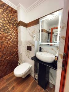 bagno con servizi igienici, lavandino e specchio di Apartament Premium Isabella a Arad