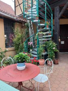 een patio met een tafel en stoelen en potplanten bij Zewwelatreppler - La Grange aux Petits Oignons - Chambre Rainette in Sélestat