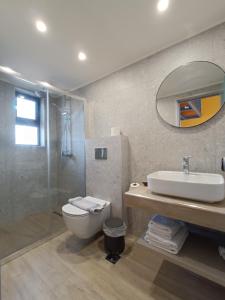 uma casa de banho com um WC, um lavatório e um chuveiro em Paraktio Beach Apartments em Kiotari