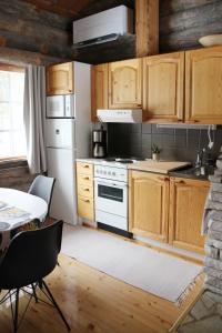 a kitchen with wooden cabinets and a white stove top oven at Lapland Cabin Vonkamies in Luosto