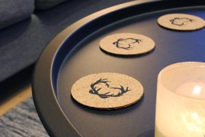a black plate with three cookies on a table with a candle at Lapland Cabin Vonkamies in Luosto