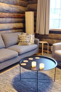 un soggiorno con divano e tavolino da caffè di Lapland Cabin Vonkamies a Luosto