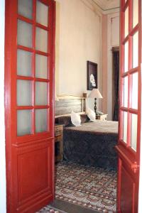 Hotel Boutique Casa de la Palma في بوبلا: غرفة نوم بسرير وباب احمر