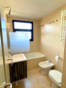 La salle de bains est pourvue d'une baignoire, d'un lavabo et de toilettes. dans l'établissement Acogedor Apartamento Monte Oiz 2 Zona Media, à Sierra Nevada