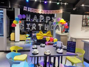 a birthday party with a table and balloons and a happy birthday sign at Yangshuo EMOJI YOUTH HOSTEL in Yangshuo