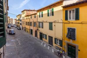 una calle vacía en un viejo pueblo con edificios en [Heart of Lucca] Style whitin the walls, en Lucca