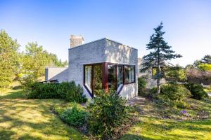 a small house on a grassy field at La Maison Fleurie - Sunny holiday home with large garden, parking, within walking distance of the sea in Koksijde