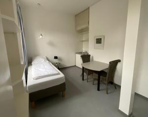 a small room with a bed and a table at Fewo Berta in Schwerin