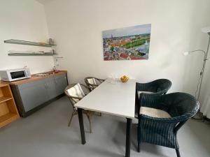 une salle à manger avec une table et des chaises blanches dans l'établissement Fewo Berta, à Schwerin