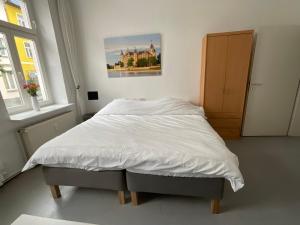 - un lit blanc dans une chambre ornée d'une peinture murale dans l'établissement Fewo Berta, à Schwerin