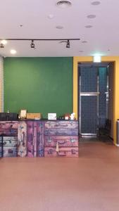 a room with a green wall and a bunch of suitcases at Chungmuro Merlin Hotel in Seoul