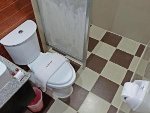 a bathroom with a white toilet and a sink at La Carmela de Boracay Hotel in Boracay