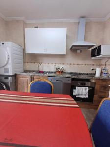 a kitchen with a red table and blue chairs at Hostal in Mieres