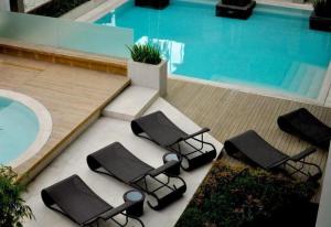 a group of chairs sitting next to a swimming pool at F1 Hotel Manila in Poblacion