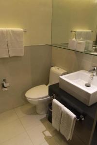 a bathroom with a white toilet and a sink at F1 Hotel Manila in Poblacion
