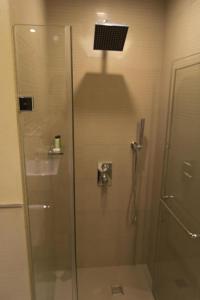 a shower with a glass door in a bathroom at F1 Hotel Manila in Poblacion