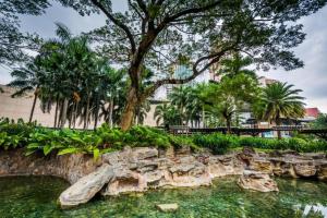 a park with a rock wall and trees and water at F1 Hotel Manila in Poblacion