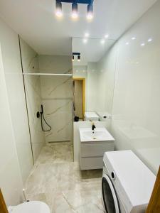y baño con aseo, lavabo y ducha. en Gold Apartament, en Świdnik