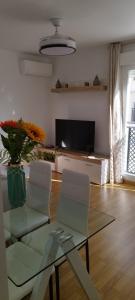 un soggiorno con tavolo, sedie e TV di Apartamento Fuente del Genil. a Fuente Vaqueros