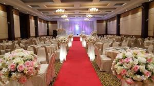 un salón de banquetes con mesas blancas, sillas y flores en Western Grand Hotel Ratchaburi (SHA Extra Plus) en Ratchaburi