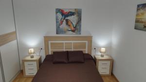 Apartamento Fuente del Genil. في Fuente Vaqueros: غرفة نوم مع سرير مع مواقف ليلتين وشموعين