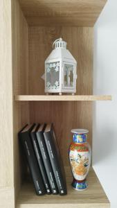 una libreria con sopra libri e un vaso di Apartamento Fuente del Genil. a Fuente Vaqueros