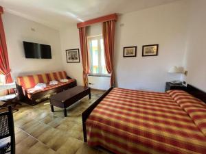 um quarto de hotel com uma cama e um sofá em Hotel Clelia em Deiva Marina