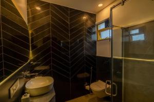 een badkamer met een toilet, een wastafel en een douche bij Touchwood Bliss Igatpuri in Nashik