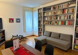 a living room with a couch and book shelves with books at Buenos Aires Urban Escape - [Metro & Self-Checkin] in Milan