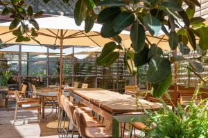 un patio con tavoli, sedie e ombrelloni di Brondo Architect Hotel a Palma de Mallorca