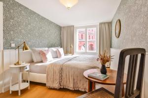 Schlafzimmer mit einem Bett, einem Tisch und einem Fenster in der Unterkunft Villa am Mägdebrunnen in Stralsund