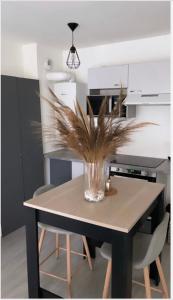 a table with a vase on it in a kitchen at Appartement cosy et bien équipé in Nanterre