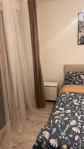 a bedroom with a bed and curtains in it at Appartement cosy et bien équipé in Nanterre