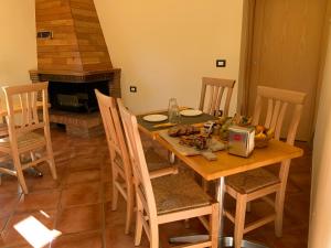 una sala da pranzo con tavolo, sedie e camino di LorichiAmo B&b a Lorica