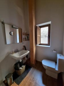 łazienka z umywalką, toaletą i oknem w obiekcie Casa Luenga w mieście Vinuesa