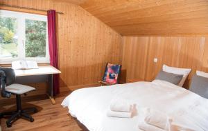 1 dormitorio con cama, escritorio y ventana en Ferienhaus Tgantieni Ski-in Ski-out-Lenzerheide, en Lenzerheide