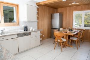 a kitchen with a table and a refrigerator at Ferienhaus Tgantieni Ski-in Ski-out-Lenzerheide in Lenzerheide