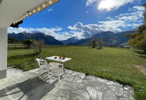 - une table et des chaises sur une terrasse avec vue sur les montagnes dans l'établissement Ferienhaus mit Garten Tgease Schilendra-Lantsch-Lenz-Lenzerheide, à Lenz