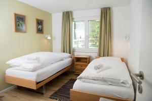 1 dormitorio con 2 camas y ventana en Ferienhaus mit Garten Tgease Schilendra-Lantsch-Lenz-Lenzerheide en Lenz