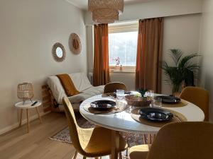 a living room with a table and chairs and a couch at Galle BnB boheemi kaksio in Pori