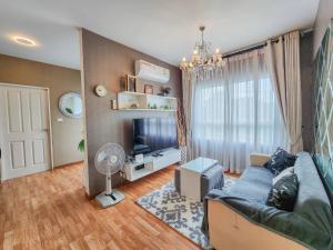 a living room with a blue couch and a television at Trust Luxury in Hua Hin