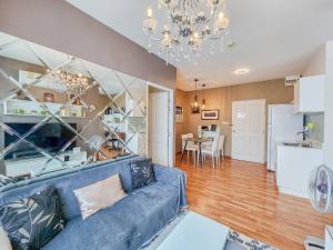 a living room with a blue couch and a kitchen at Trust Luxury in Hua Hin