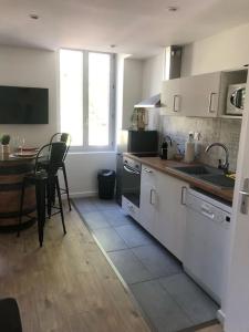 uma cozinha com um lavatório e uma mesa com cadeiras em Appartement Vignes 2 personnes em Vienne