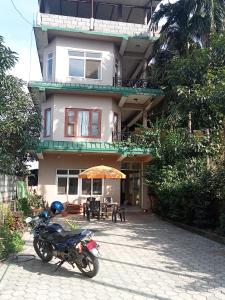 a motorcycle parked in front of a house at Hotel Holidays Inn - Bagpacker's Home in Sauraha