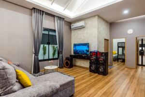 uma sala de estar com um sofá e uma televisão de ecrã plano em PP POOL VILLA @ CHA-AM (ทรัพย์เพิ่มพูนพูลวิลล่า) em Ban Hup Kaphong