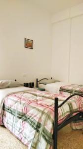 two beds in a bedroom with a picture on the wall at APPARTAMENTO LA SPIAGGETTA in Foligno