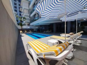 2 ligstoelen en een parasol naast een zwembad bij City 2 in Alanya