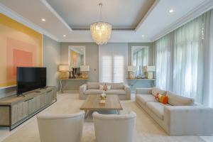 a living room with a couch and a tv at Maison Privee - Prvt Pool & Beach Access in Luxury Palm Jumeirah 6BR Villa in Dubai